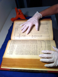 archives gloves looking at rare book